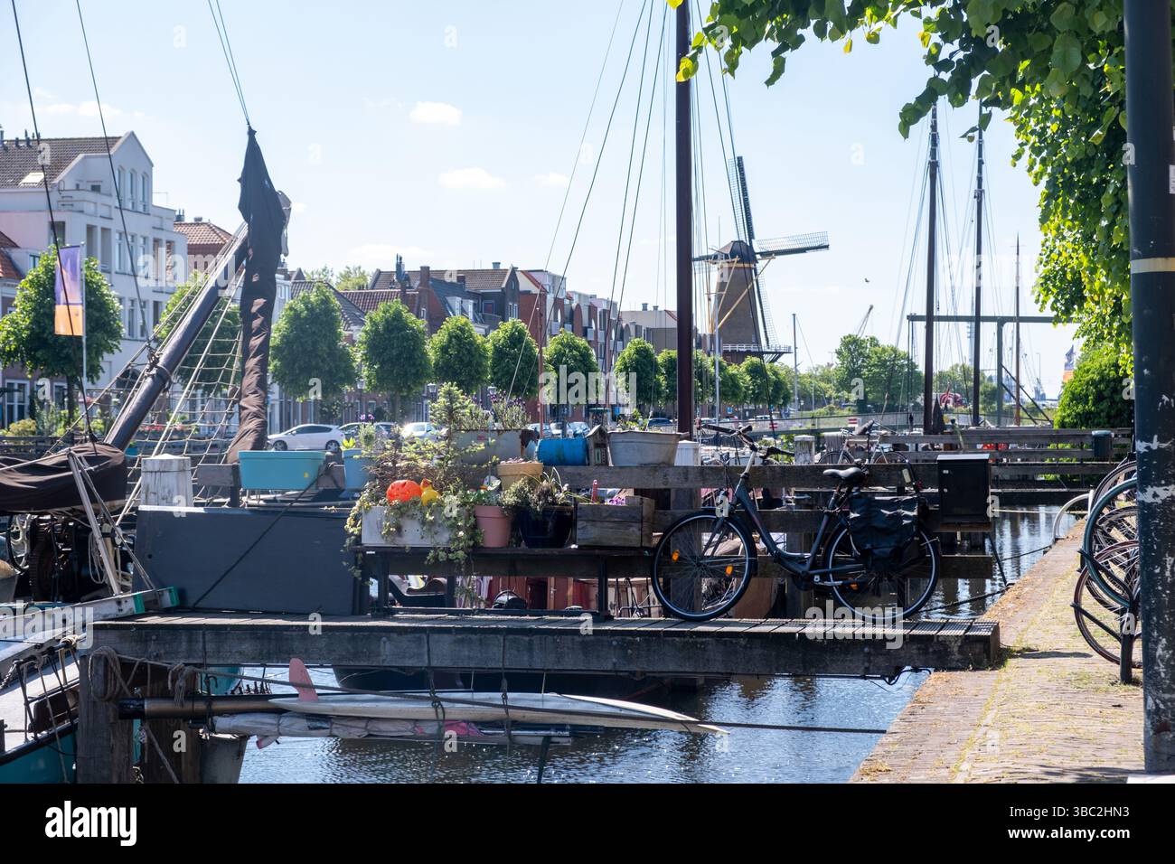 Delfshaven pays-Bas Hollande. Vélo garé au-dessus de l'eau de la rivière, les bâtiments de bord de mer de la ville et les bateaux fond. Banque D'Images