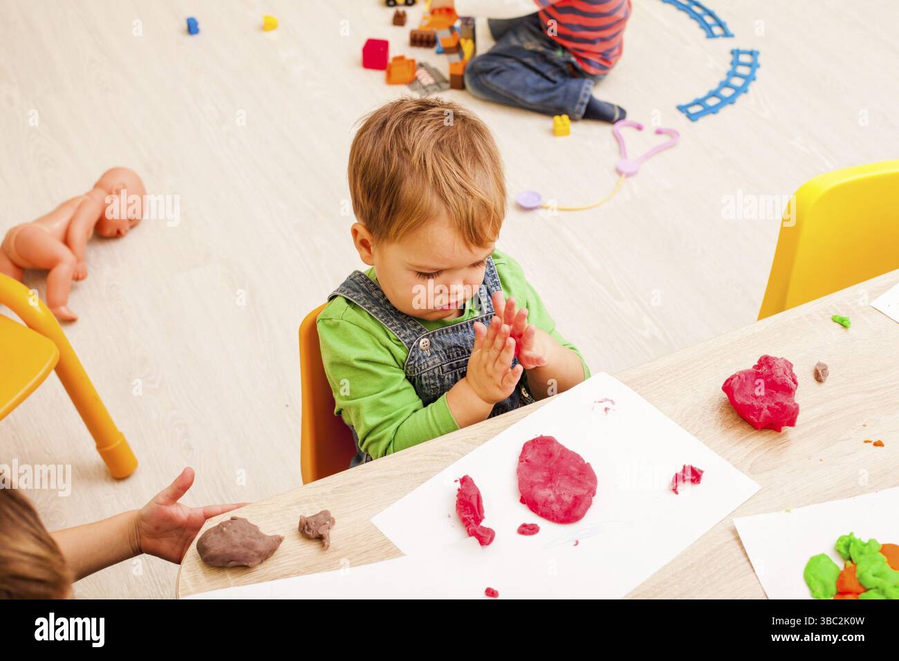 Les enfants jouent avec de l'argile à modeler sur la table Banque D'Images