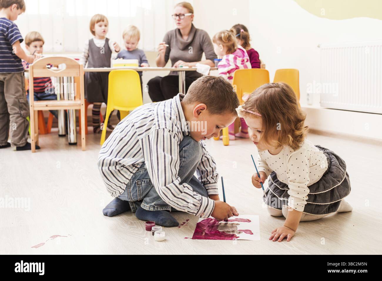Les enfants sont la peinture avec un pinceau et d'aquarelles sur papier dans le jardin d'enfants Banque D'Images