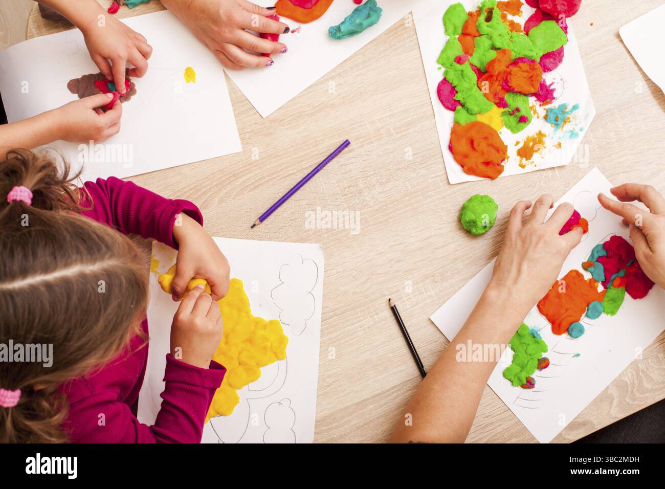 Les enfants jouent avec de l'argile à modeler sur la table Banque D'Images