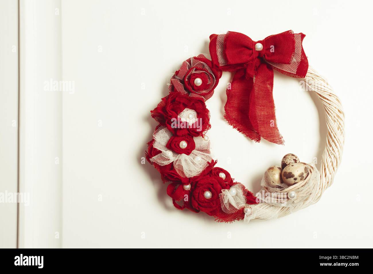 Couronne de Pâques ornée d'un noeud rouge sur la porte avant Banque D'Images