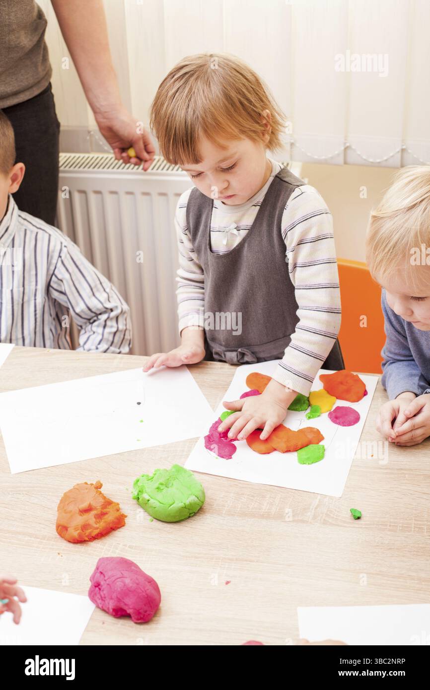Les enfants font une figure de plasticine sur la table Banque D'Images