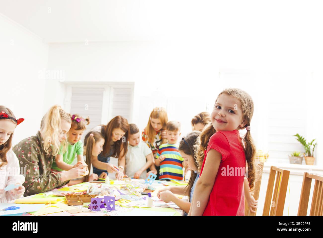 Les enfants font des bricolages en papier avec un professeur à l'atelier créatif Banque D'Images