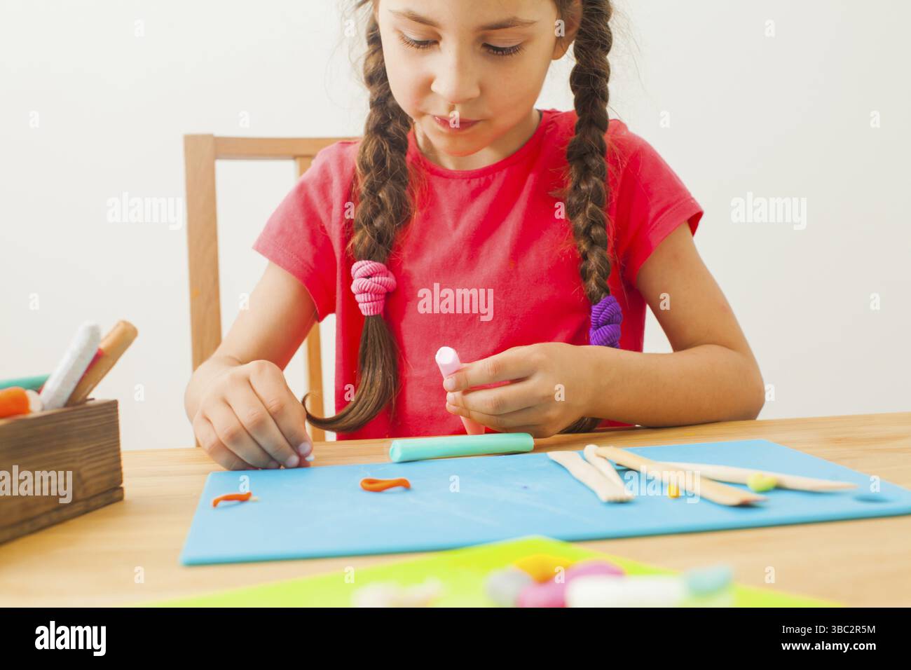 Creative kid molding à la maison. 7 année vieille fille sculpte avec la pâte à modeler ou de la pâte et des piles Banque D'Images