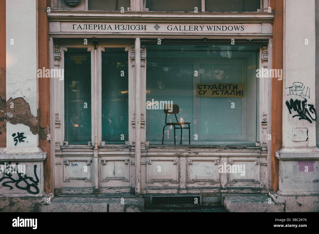 Belgrade, Serbie - 13 mai 2025 : devanture vide d'une ancienne galerie avec une chaise et l'inscription étudiants se sont levés. Banque D'Images