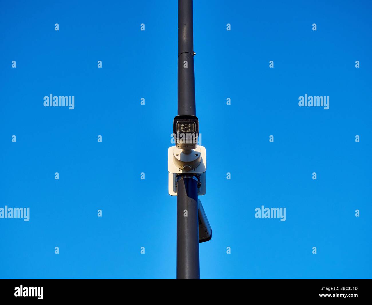 Caméra de surveillance moderne sur un poteau contre Clear Blue Sky Banque D'Images