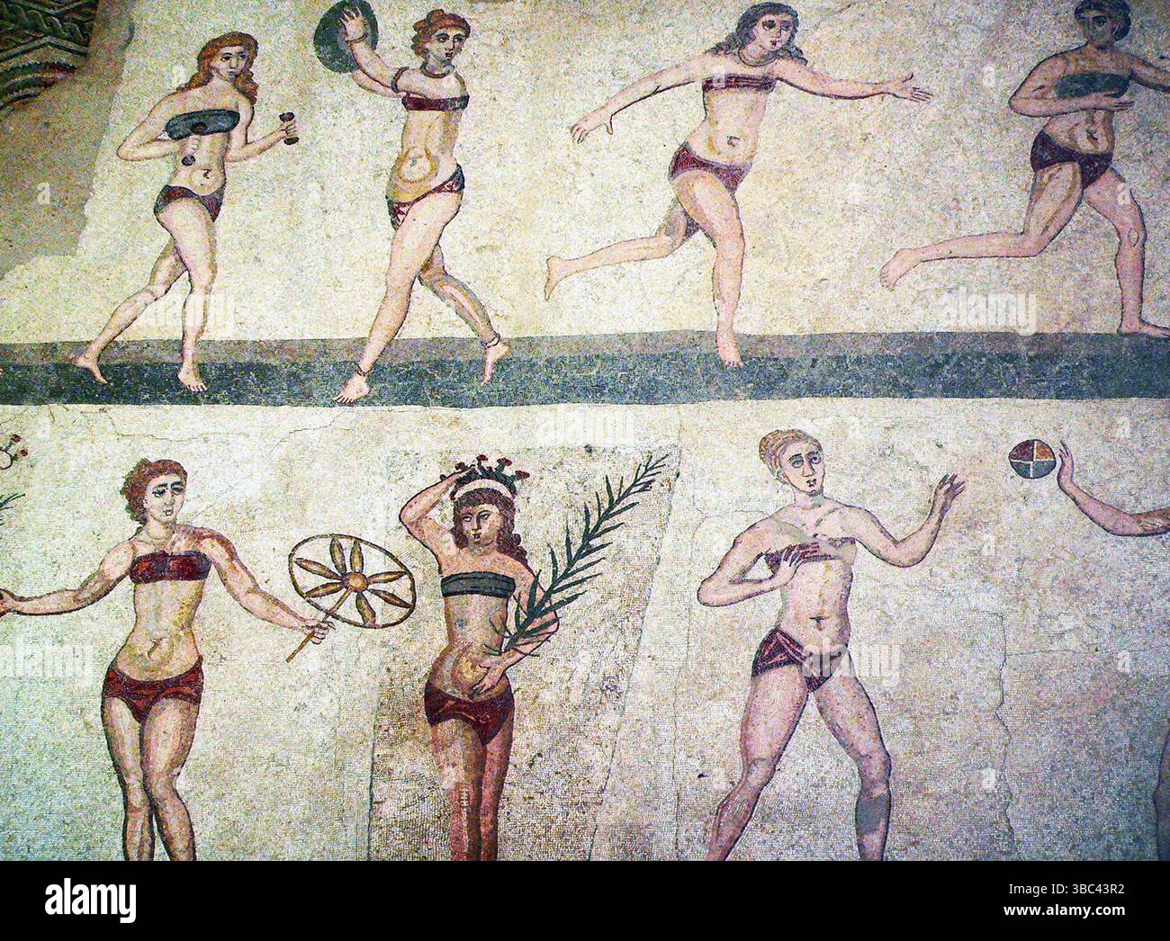Célèbre mosaïque de filles bikini (trouvée par des fouilles archéologiques de l'ancienne villa romaine près de Piazza Armerina en Sicile), montrant des femmes exerçant, courant, ou recevant la paume de la victoire et de la couronne (pour avoir gagné une compétition athlétique). Bikini Mosaic Villa Romana del Casale Banque D'Images