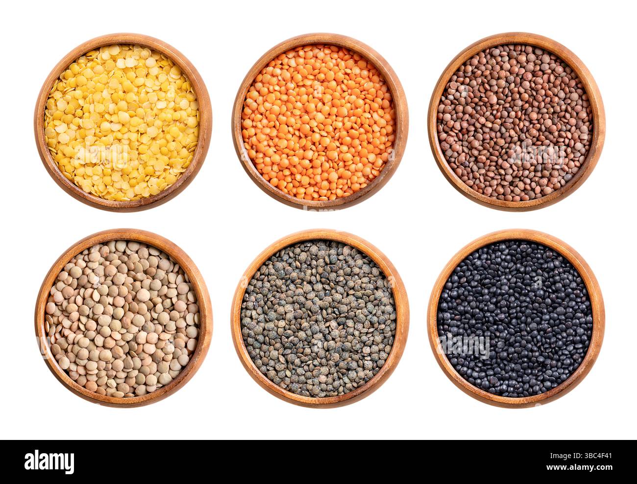 Lentilles, graines séchées de Lens esculenta dans des bols en bois. Lentilles jaunes, rouges et brunes, grandes lentilles vertes, lentilles Puy et Beluga. Banque D'Images