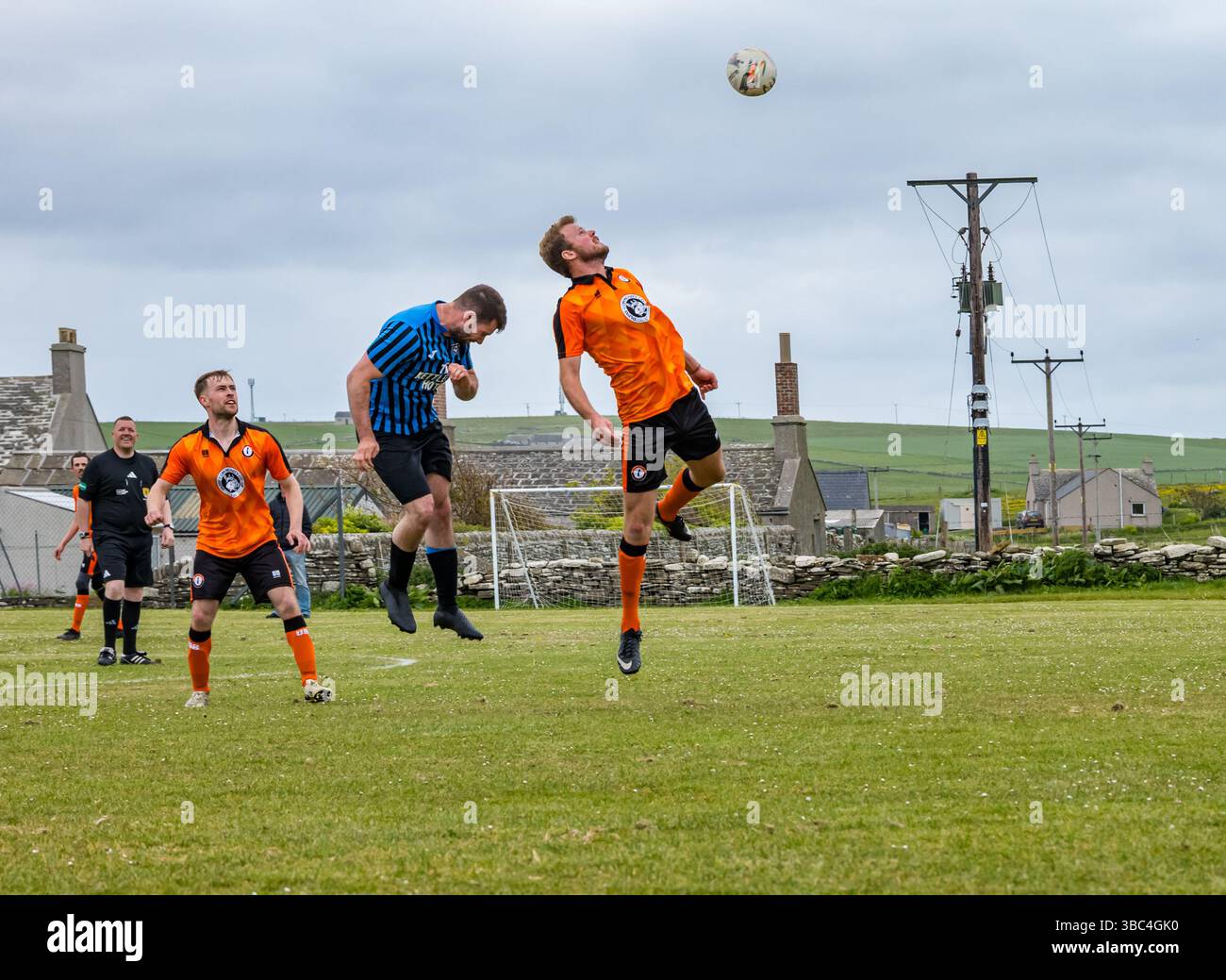 Pierowall, Westray, Orcades, Écosse, Royaume-Uni. Papa Westray v Sanday 2nd leg football matc in Orkney amateur Football Association League ou Orcadian Cup : la famille Houston trigénérationnelle) dans l'équipe de Papa Westray (alias les Doondies en maillots orange) allant dans l'âge de 63 à 19 ans, avec une population de 90 et aucun terrain de football à pratiquer sur perdre 7-1 ayant perdu 6-0 dans la 1ère manche. Ils étaient ravis de marquer un but avec un penalty dans les dernières minutes du match. De nombreux habitants de Papa Westray sont venus de l'île pour les soutenir. Crédit : Sally Anderson/Alamy Live News Banque D'Images