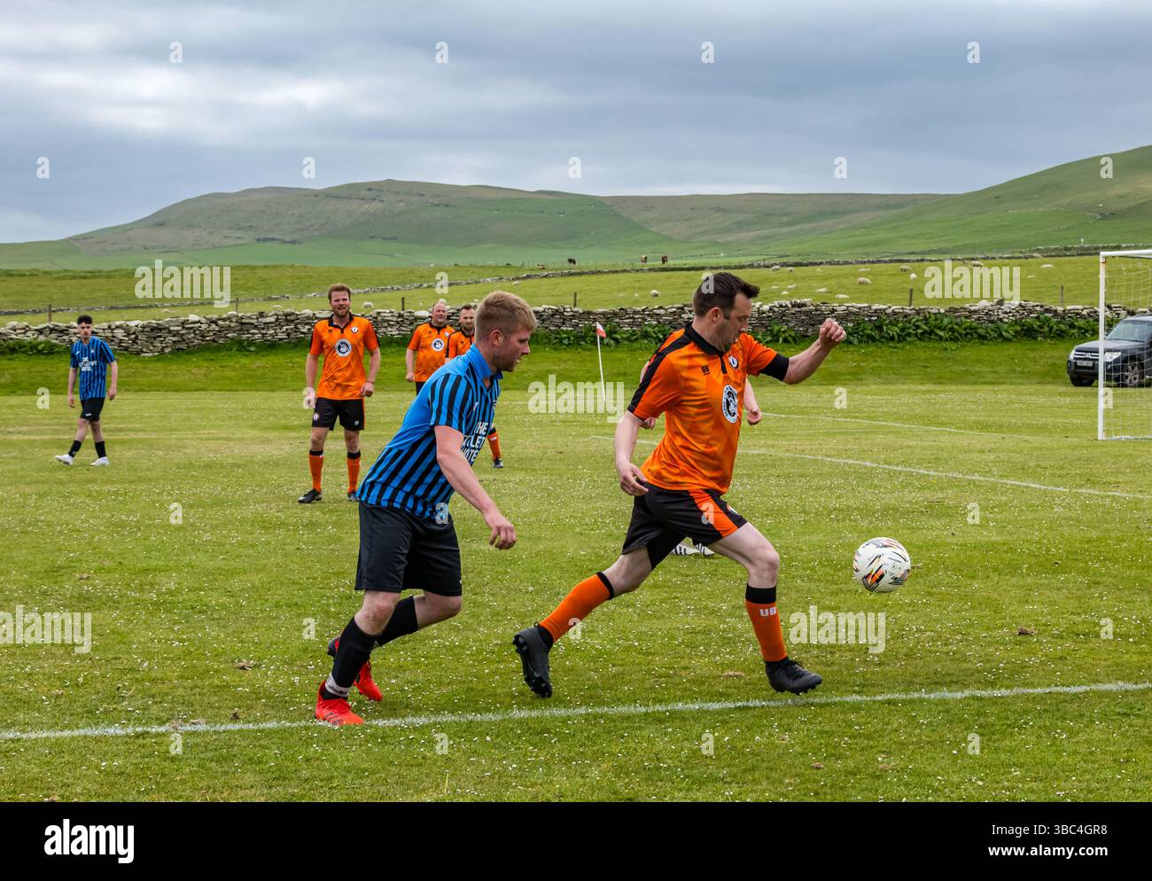 Pierowall, Westray, Orcades, Écosse, Royaume-Uni. Papa Westray v Sanday 2nd leg football matc in Orkney amateur Football Association League ou Orcadian Cup : la famille Houston trigénérationnelle) dans l'équipe de Papa Westray (alias les Doondies en maillots orange) allant dans l'âge de 63 à 19 ans, avec une population de 90 et aucun terrain de football à pratiquer sur perdre 7-1 ayant perdu 6-0 dans la 1ère manche. Ils étaient ravis de marquer un but avec un penalty dans les dernières minutes du match. De nombreux habitants de Papa Westray sont venus de l'île pour les soutenir. Crédit : Sally Anderson/Alamy Live News Banque D'Images