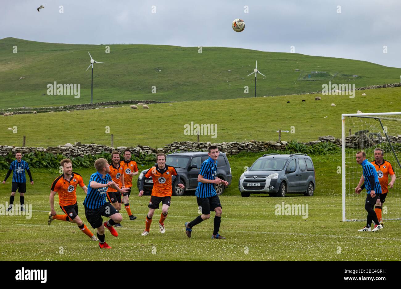 Pierowall, Westray, Orcades, Écosse, Royaume-Uni. Papa Westray v Sanday 2nd leg football matc in Orkney amateur Football Association League ou Orcadian Cup : la famille Houston trigénérationnelle) dans l'équipe de Papa Westray (alias les Doondies en maillots orange) allant dans l'âge de 63 à 19 ans, avec une population de 90 et aucun terrain de football à pratiquer sur perdre 7-1 ayant perdu 6-0 dans la 1ère manche. Ils étaient ravis de marquer un but avec un penalty dans les dernières minutes du match. De nombreux habitants de Papa Westray sont venus de l'île pour les soutenir. Crédit : Sally Anderson/Alamy Live News Banque D'Images