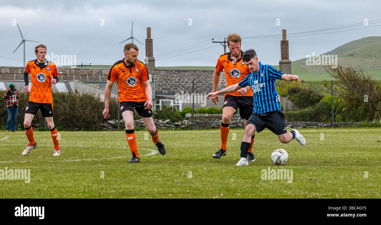 Pierowall, Westray, Orcades, Écosse, Royaume-Uni. Papa Westray v Sanday 2nd leg football matc in Orkney amateur Football Association League ou Orcadian Cup : la famille Houston trigénérationnelle) dans l'équipe de Papa Westray (alias les Doondies en maillots orange) allant dans l'âge de 63 à 19 ans, avec une population de 90 et aucun terrain de football à pratiquer sur perdre 7-1 ayant perdu 6-0 dans la 1ère manche. Ils étaient ravis de marquer un but avec un penalty dans les dernières minutes du match. De nombreux habitants de Papa Westray sont venus de l'île pour les soutenir. Crédit : Sally Anderson/Alamy Live News Banque D'Images