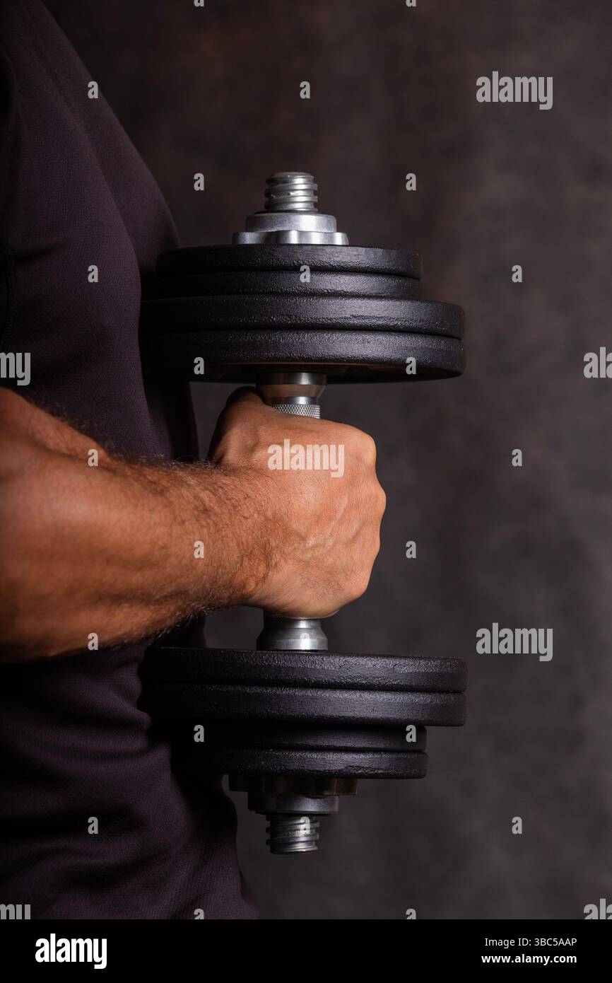 gros plan d'un haltère à un bras pour l'exercice tenu par une main masculine forte et bien entraînée Banque D'Images