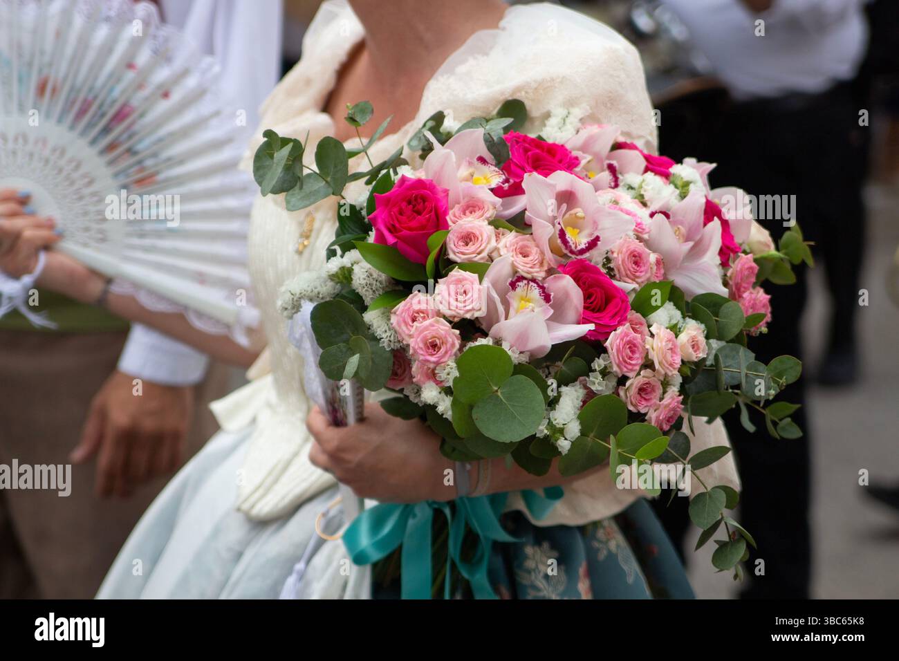 Femme en costume traditionnel portant un bouquet de fleurs pendant la procession de rue à l'église de Villajoyosa, Espagne Banque D'Images