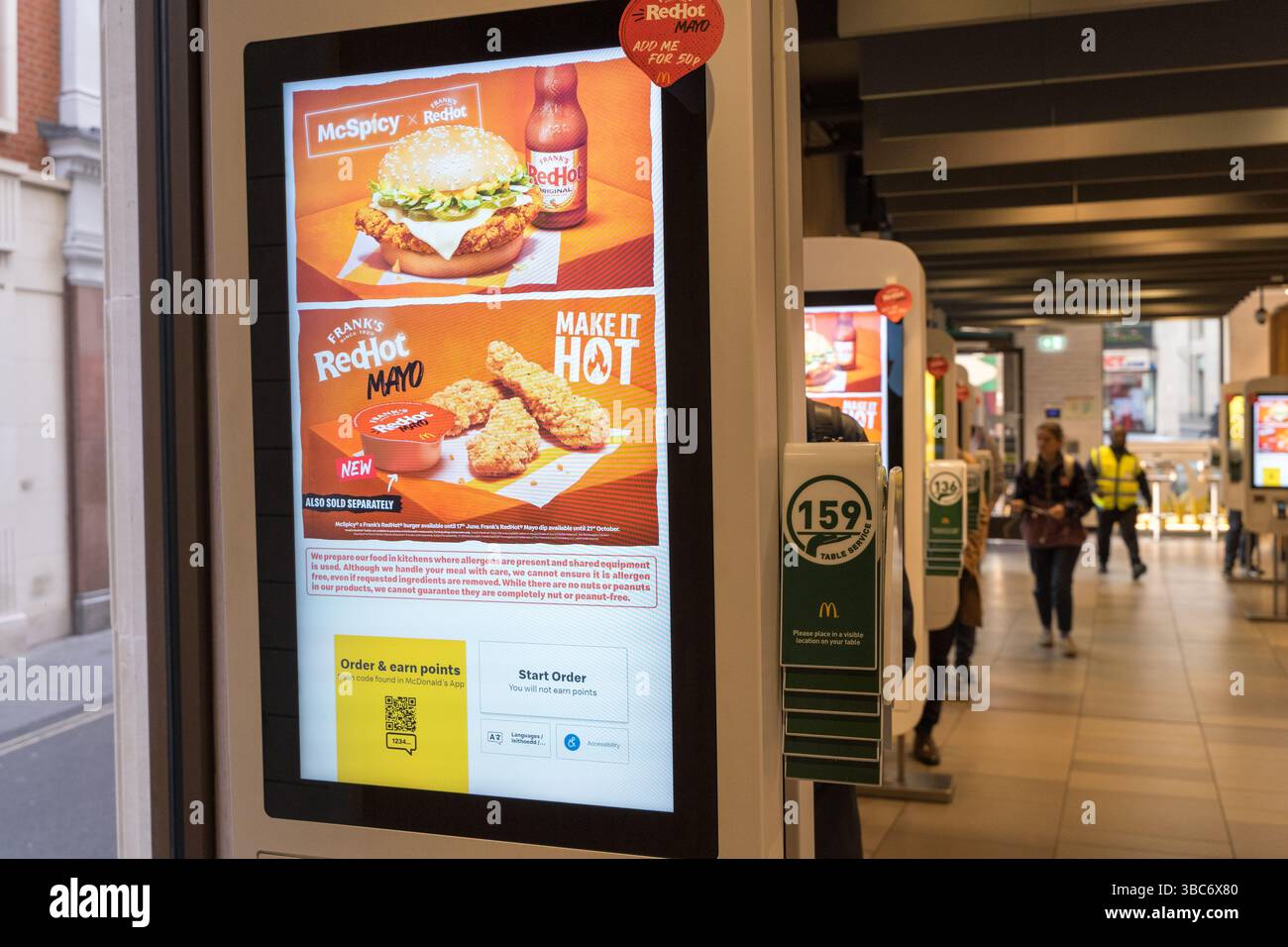 Une promotion de hamburger McSpicy apparaît sur l’écran de commande automatique dans un restaurant McDonald’s, l’expérience de menu numérique et l’article en vedette. Banque D'Images