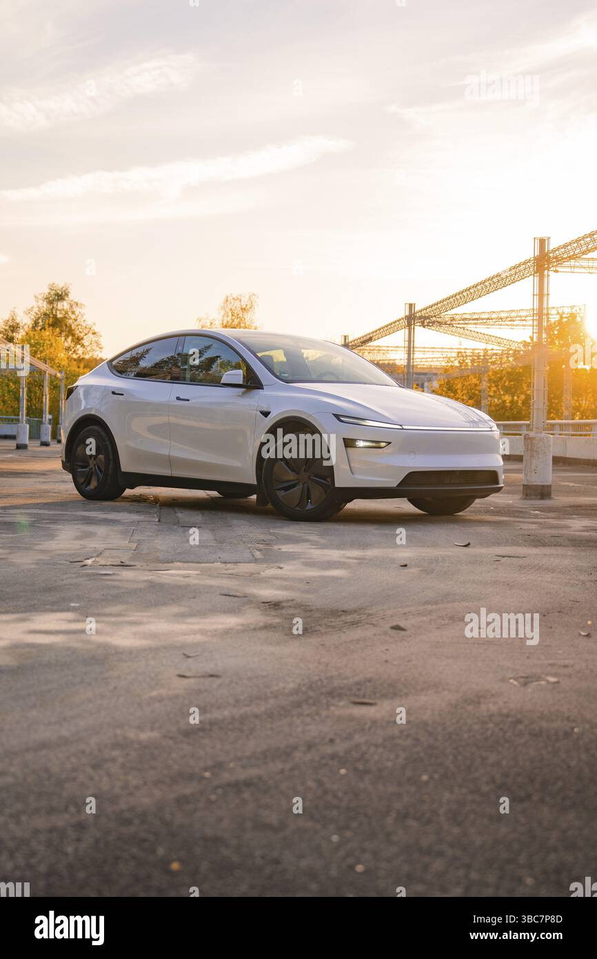 Une voiture blanche dans un parking urbain au lever du soleil, Tesla New Model y Juniper, Nagold, Allemagne, Europe Banque D'Images