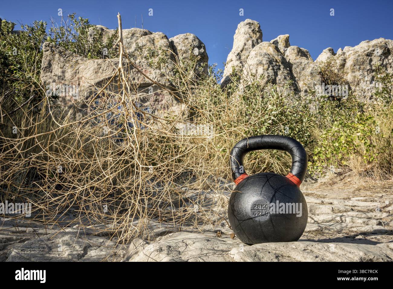 Concept de remise en forme en plein air - kettlebell en fer lourd à l'affleurement rocheux avec un tumbleweed Banque D'Images