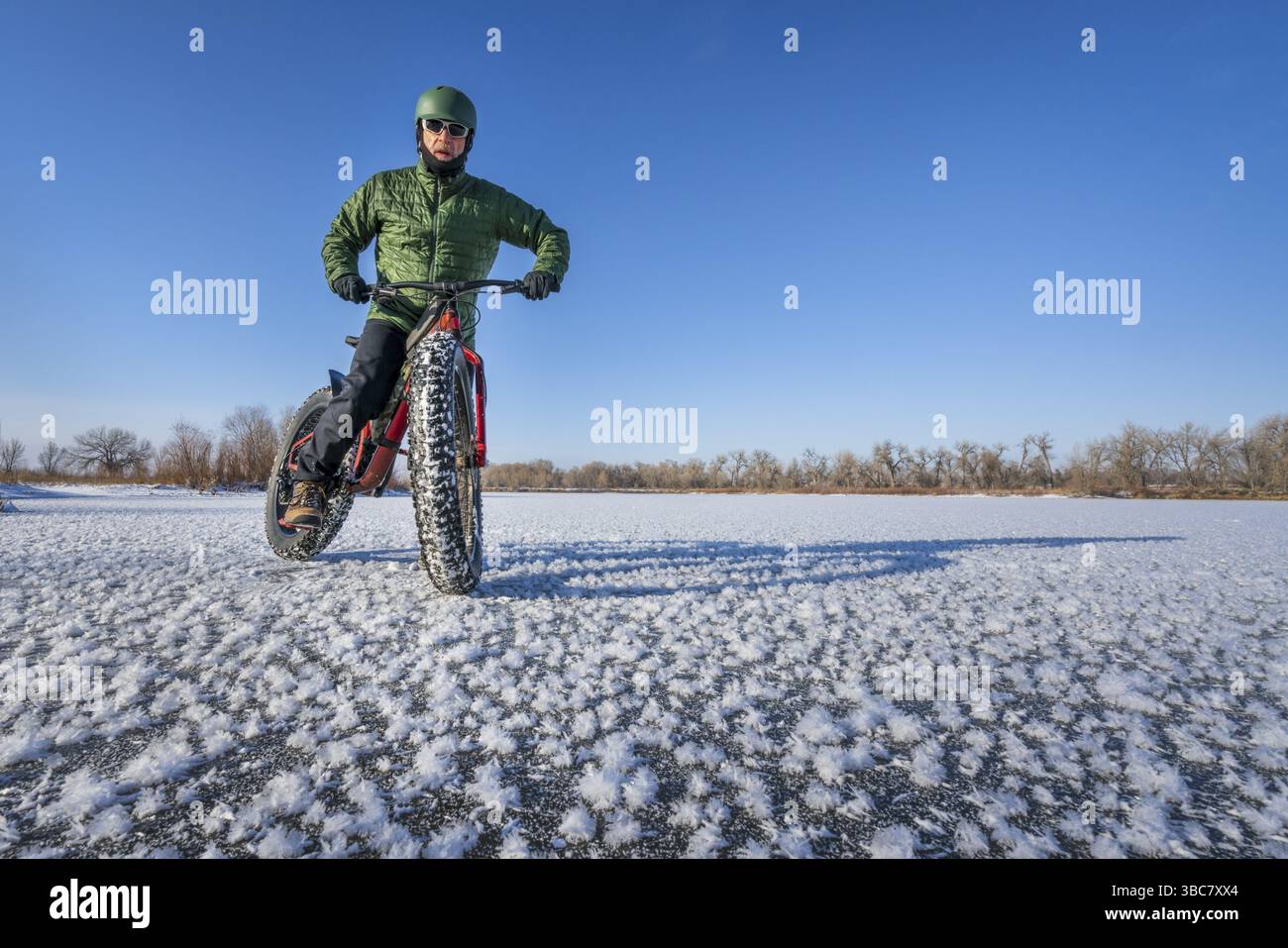 Un cycliste masculin avec son gros vélo de montagne sur un lac gelé dans le nord du Colorado Banque D'Images