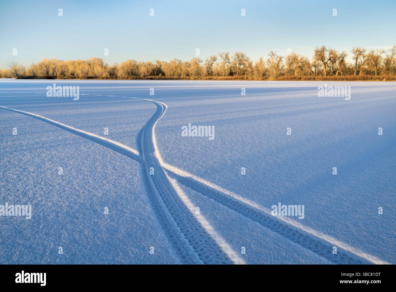 Empreintes d'un vélo à gros pneus sur un lac gelé dans le nord du Colorado Banque D'Images