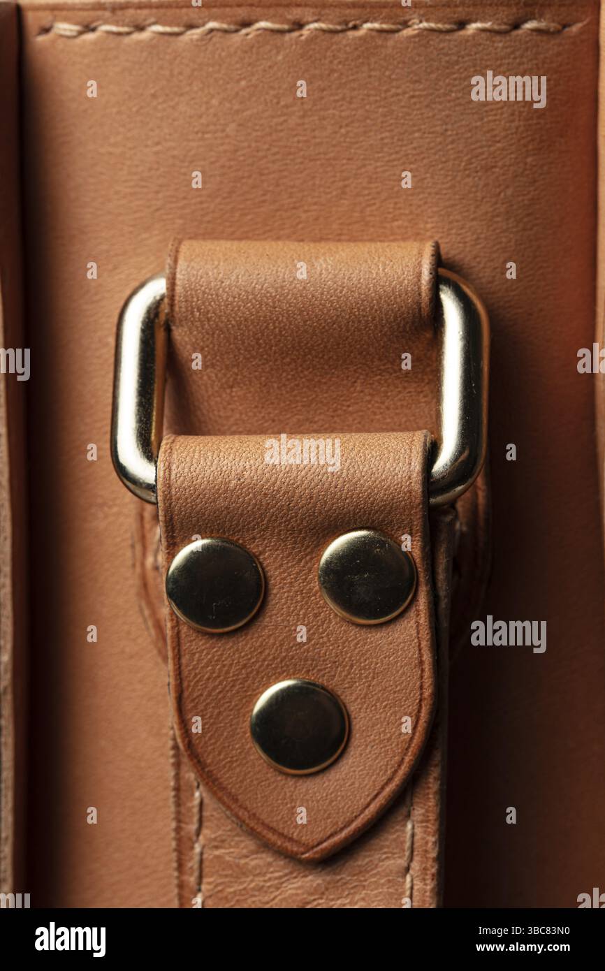 Partie d'un sac en cuir véritable marron avec une attache en métal pour la poignée Banque D'Images