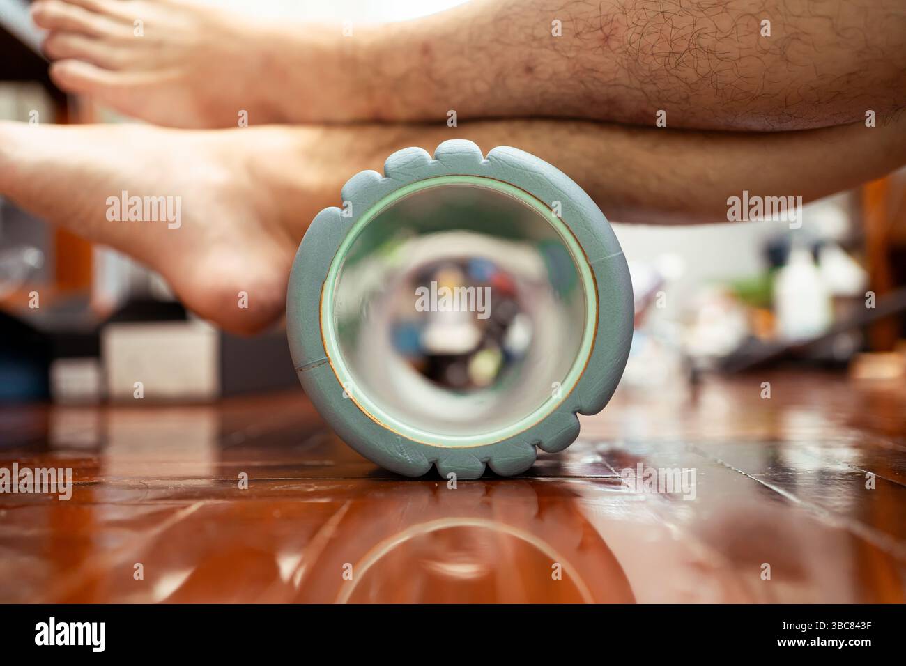 Utiliser un rouleau en mousse pour étirer le muscle du mollet et soulager la douleur au talon. Les exercices de rouleau de mousse sont utiles pour la récupération d'un coureur. Banque D'Images