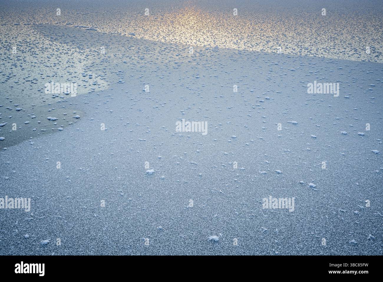 Cristaux de glace sur un lac gelé avec reflet du coucher du soleil dans le nord du Colorado Banque D'Images