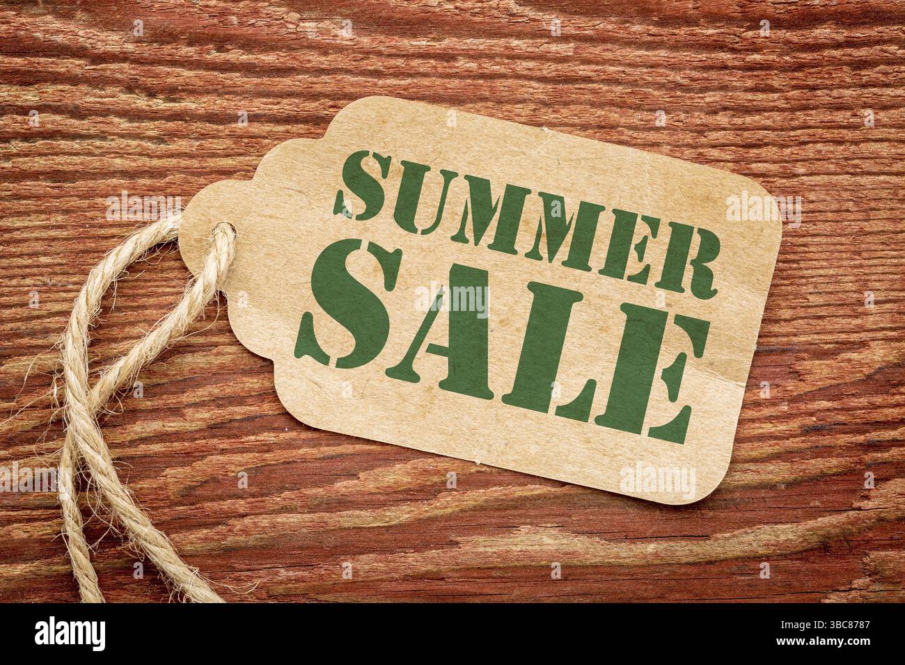 Affiche de solde d'été - une étiquette de prix en papier contre le bois rustique peint en rouge de grange Banque D'Images