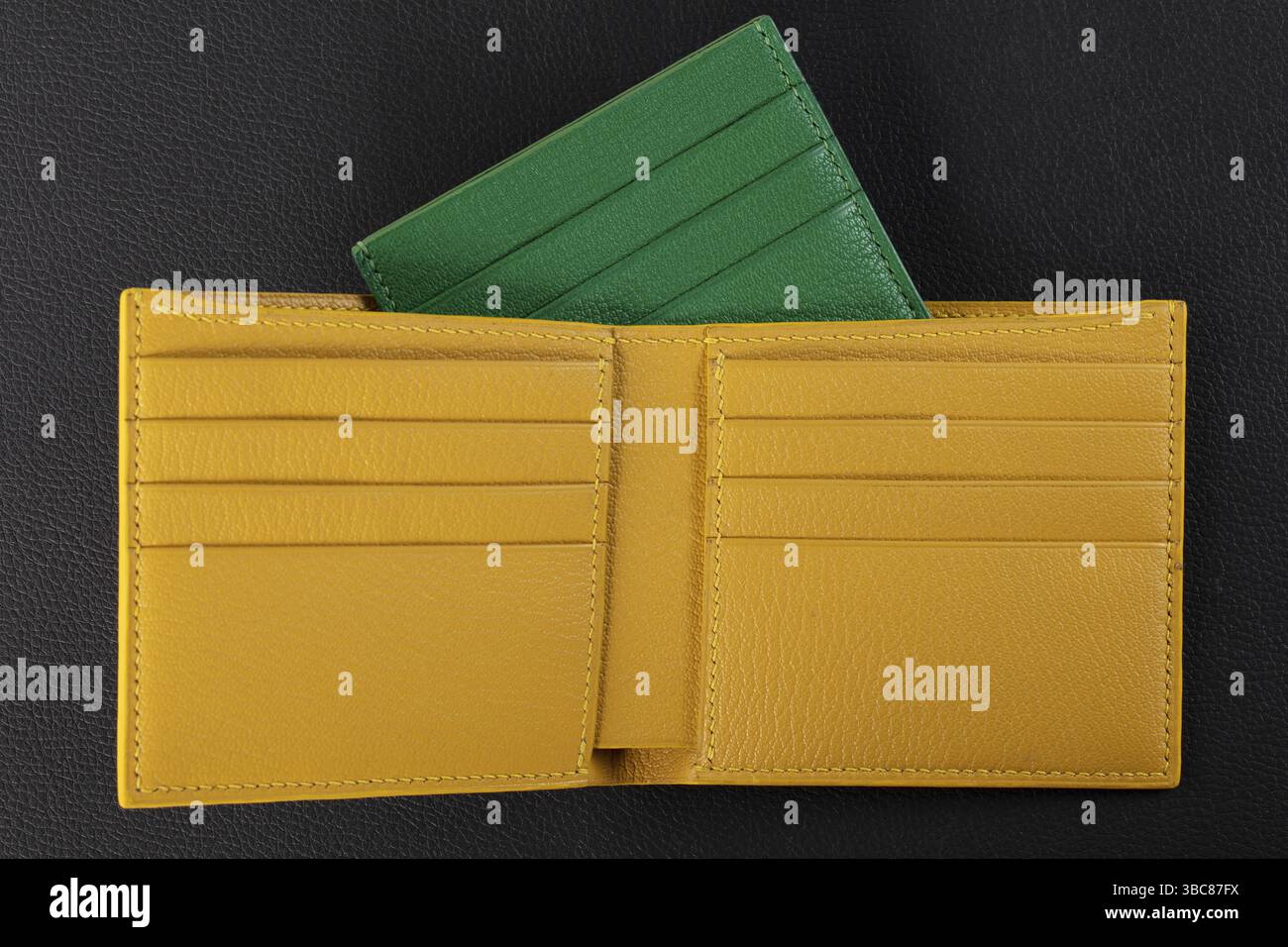 Produits en cuir. Porte-cartes de visite portefeuille en cuir véritable vert et jaune sur fond noir Banque D'Images