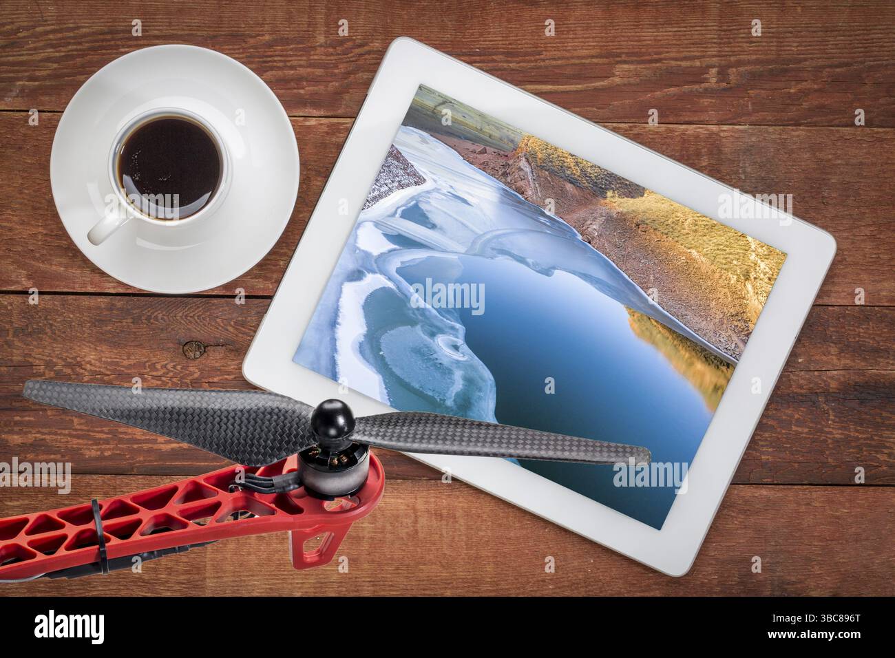 Lac de montagne partiellement gelé dans les contreforts du nord du Colorado, examen d'une image aérienne sur une tablette numérique Banque D'Images