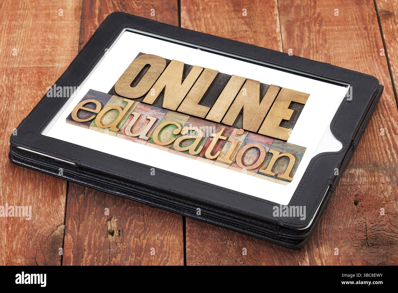 Éducation en ligne - texte en typographie type bois sur une tablette numérique contre bois de grange rouge Banque D'Images