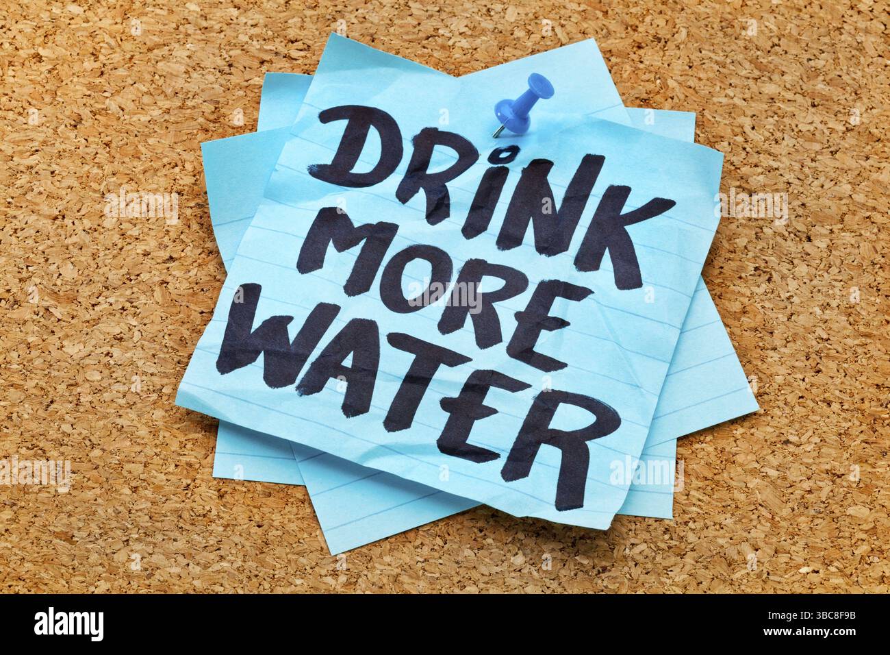 Buvez plus d'eau - rappel d'hydratation - écriture manuscrite sur note collante bleue postée sur le panneau de liège Banque D'Images Buvez plus d'eau - rappel d'hydratation - écriture manuscrite sur note collante bleue postée sur le panneau de liège Banque D'Images
