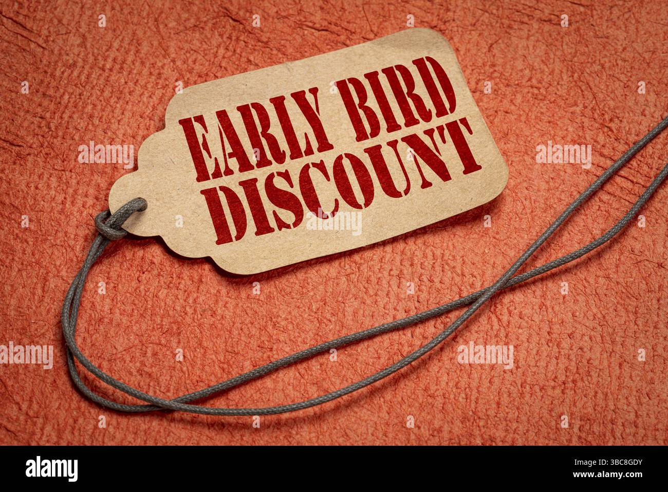 Rabais pour les lève-tôt - texte sur une étiquette de prix en papier avec une ficelle contre du papier d'écorce texturé Banque D'Images