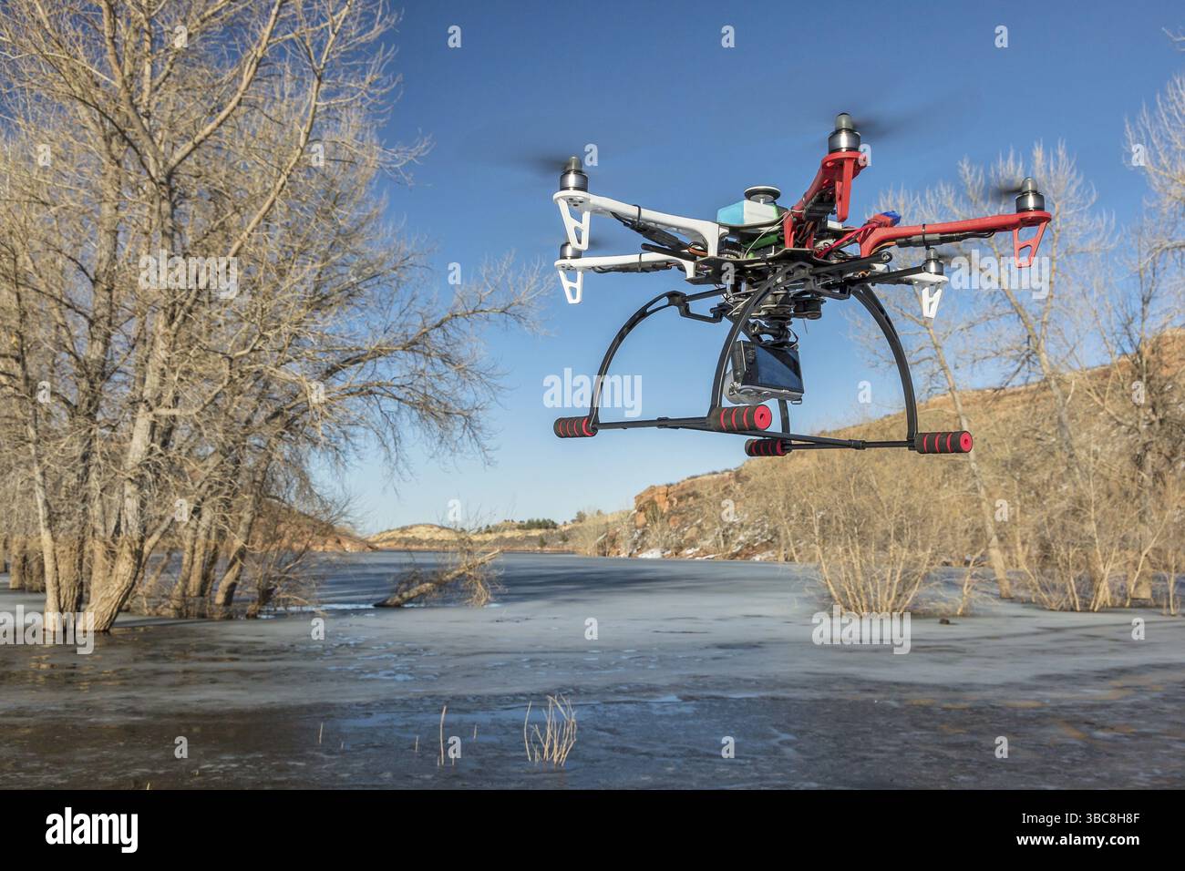 FORT COLLINS, CO, États-Unis, 9 mars 2015 : le drone hexacoptère DJI F550 Flame Wheel vole avec une caméra au-dessus d'un lac gelé, en Amérique du Nord Banque D'Images