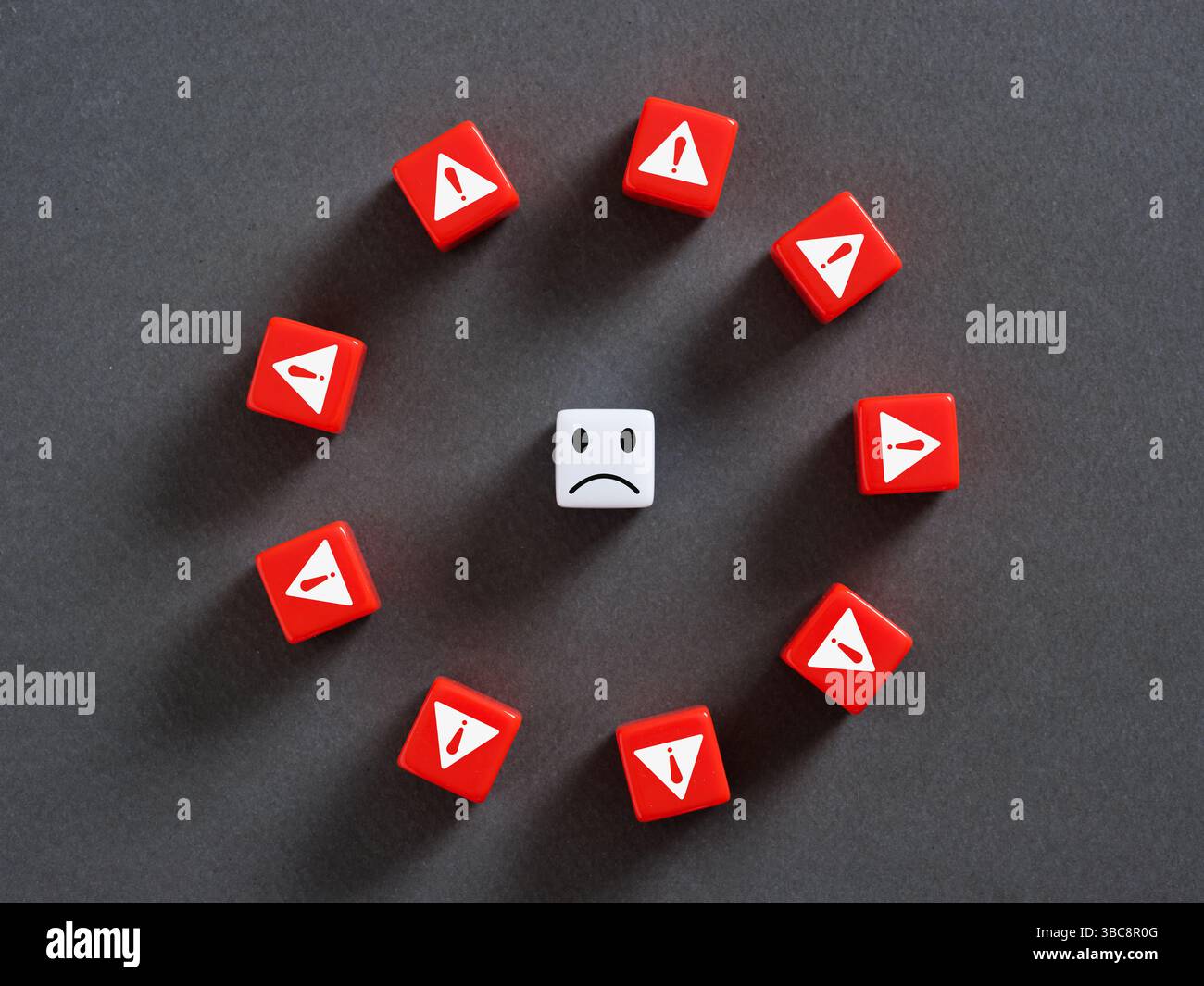 Cube blanc avec visage triste est entouré de cubes rouges avec des points d'exclamation montrant les risques, les problèmes et l'incertitude Banque D'Images