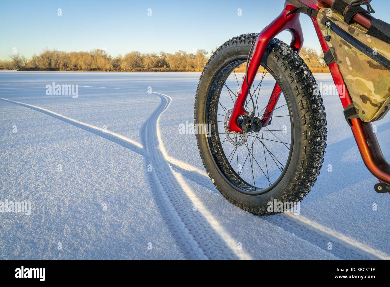 Gros vélo, empreintes de pas et ombres sur un lac gelé dans le nord du Colorado Banque D'Images