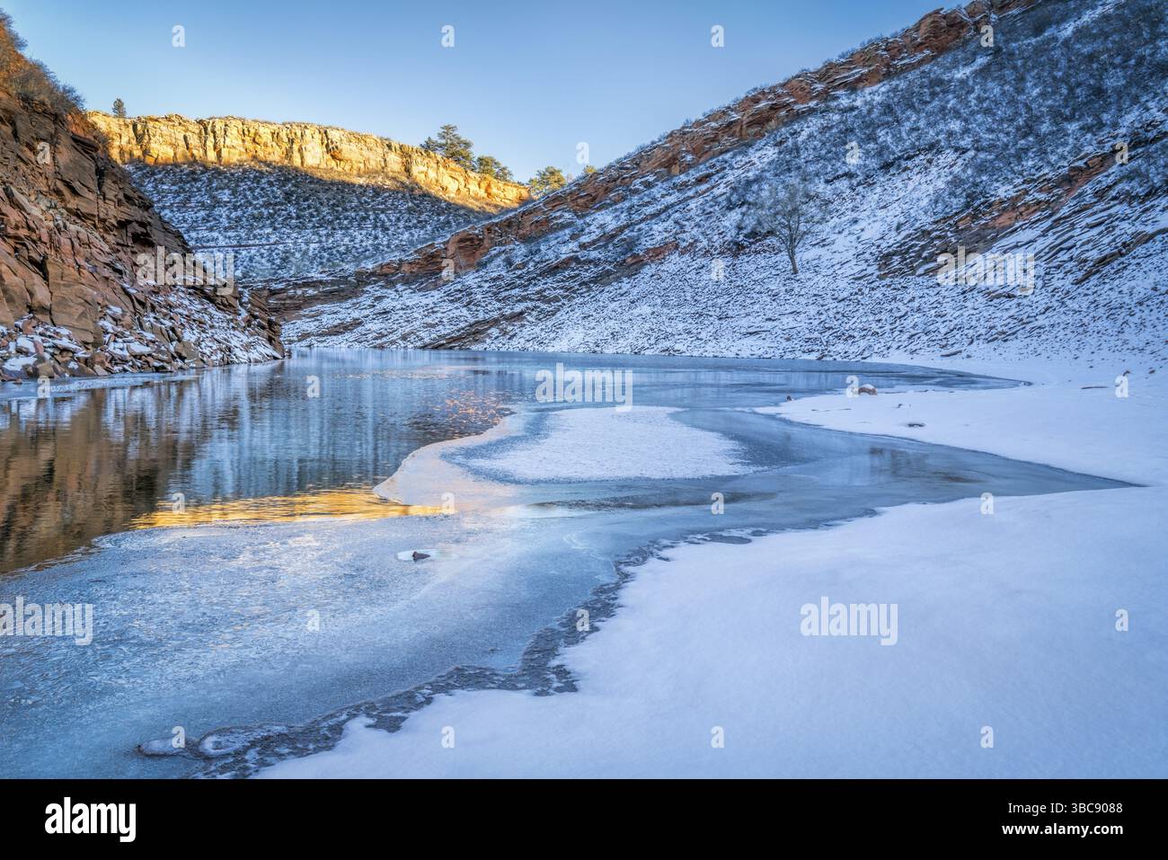 Calme coucher de soleil hivernal sur Horsetooth Reservoir partiellement gelé près de Fort Collins dans le nord du Colorado Banque D'Images