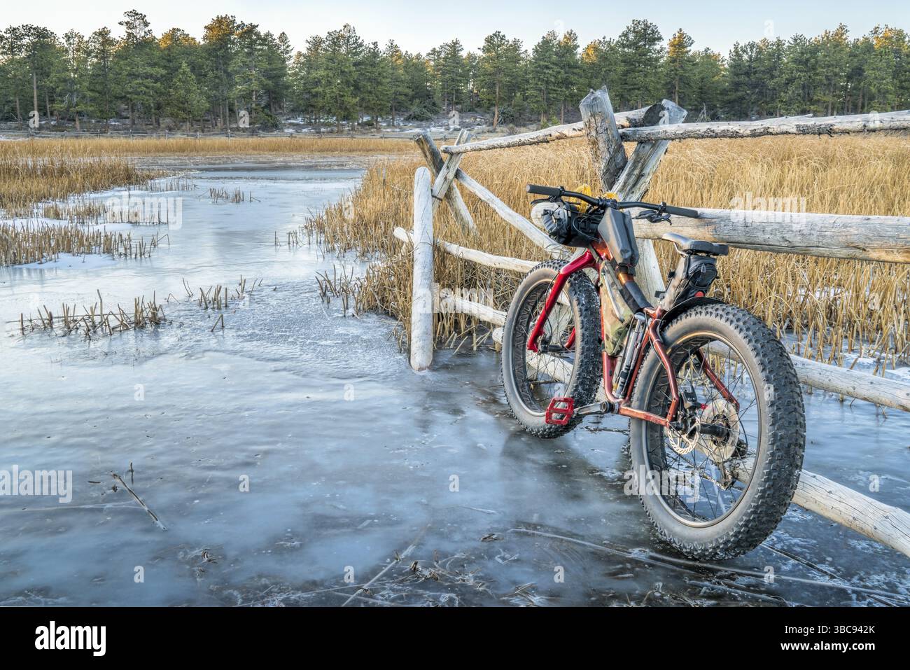 Gros vélo avec sacs de cadre sur le ruisseau couvert de glace dans les montagnes Rocheuses du Colorado Banque D'Images