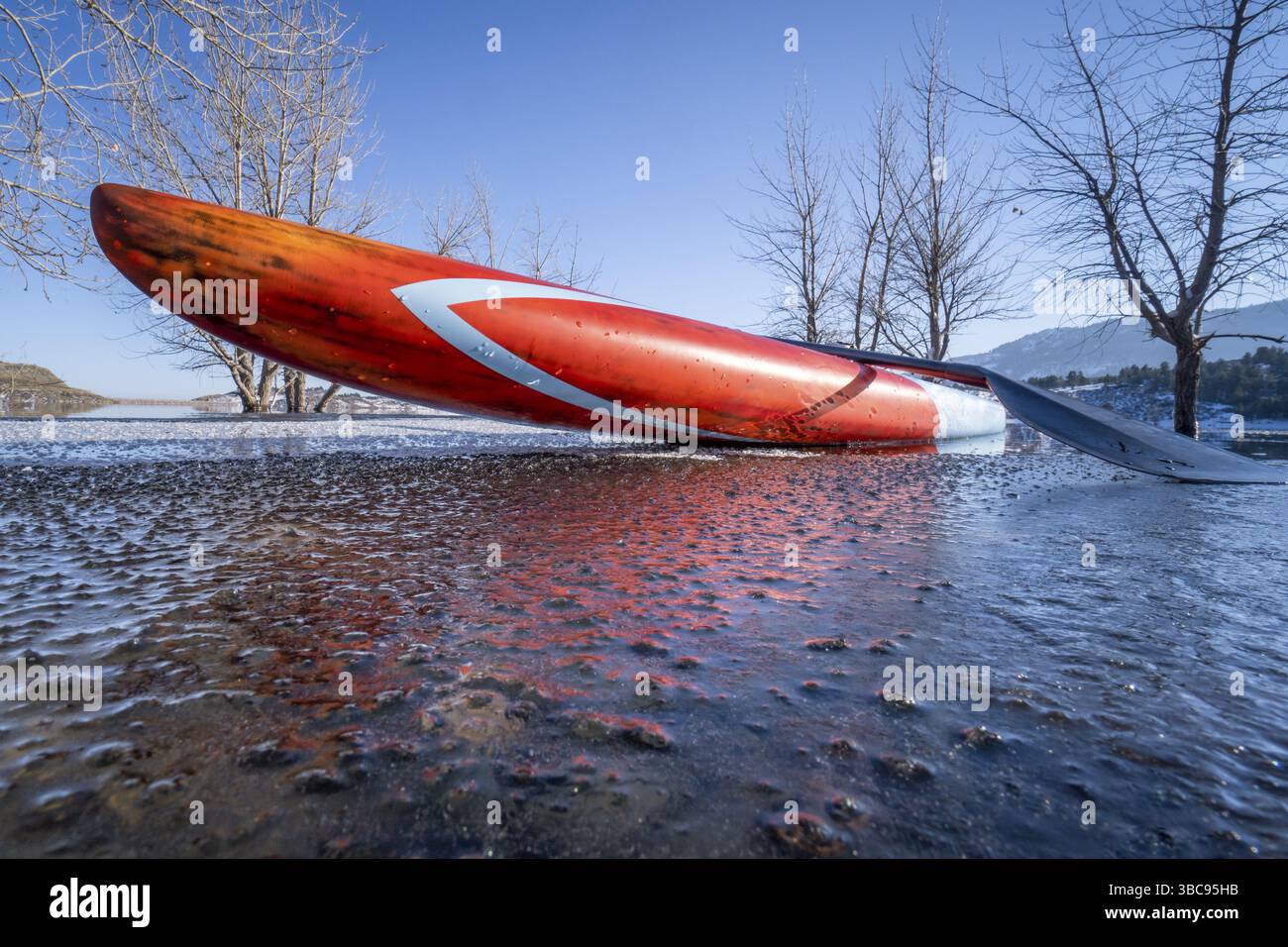 Stand up paddleboard sur un lac partiellement gelé - Horsetooth Reservoir dans le nord du Colorado, pagayage hivernal, fitness et concept d'entraînement Banque D'Images