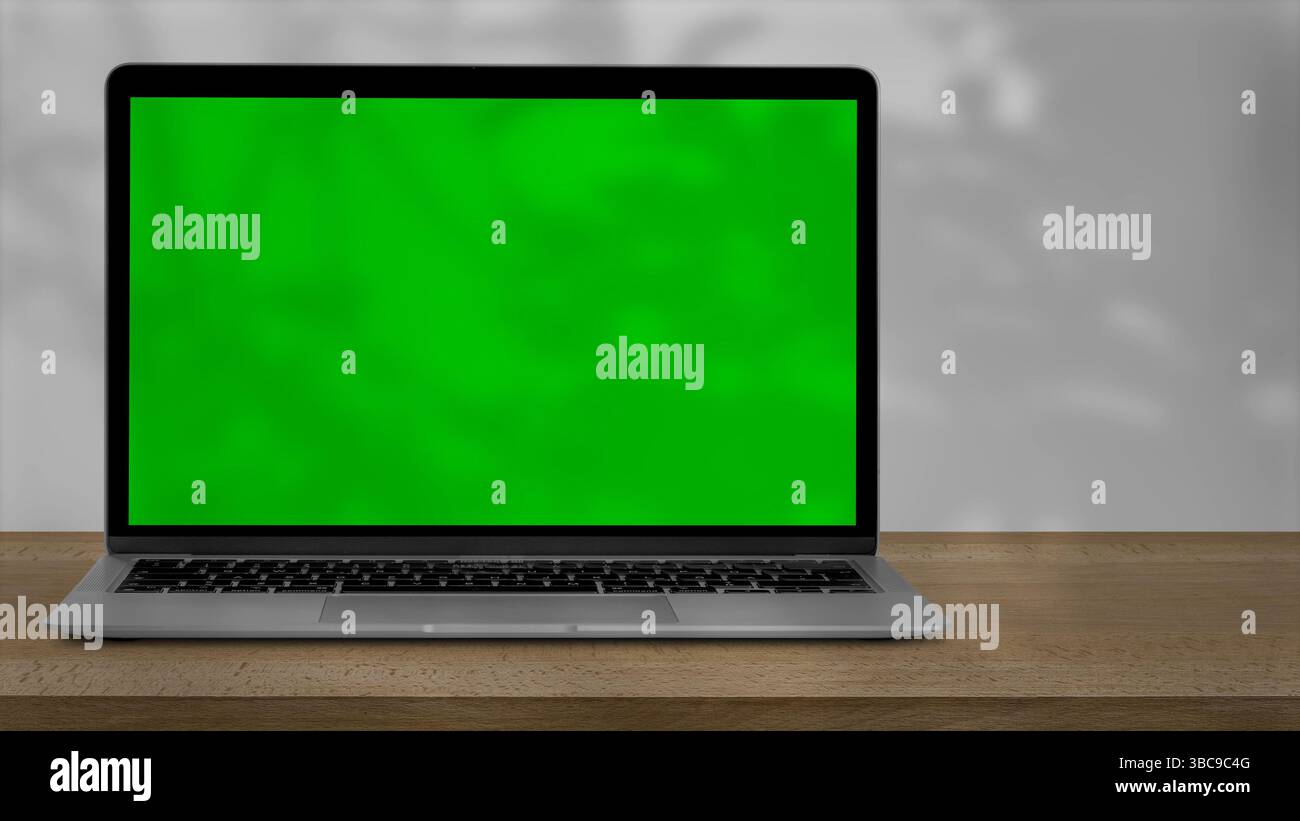 Tablette avec écran vert à l'extérieur, arbres se balançant en arrière-plan. Banque D'Images