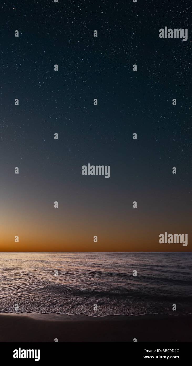 Lever de soleil sur la mer avec des vagues douces et des étoiles qui s'estompent dans une atmosphère paisible et rêveuse Banque D'Images