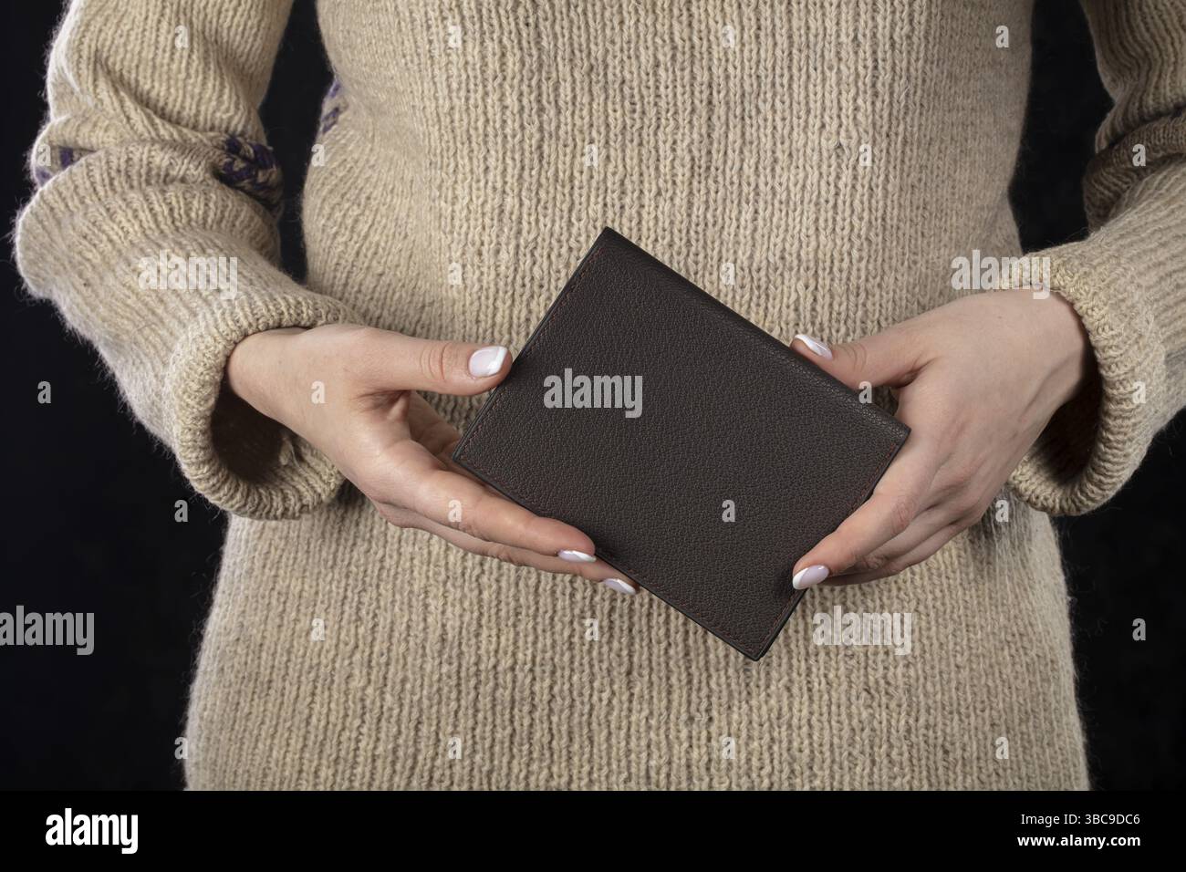 Un portefeuille en cuir marron est entre les mains d'une femme Banque D'Images