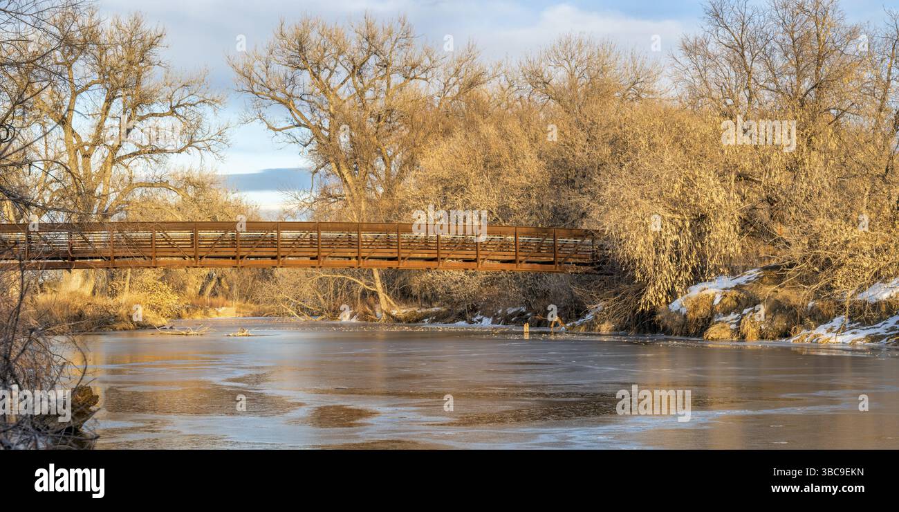 Passerelle au-dessus de la rivière gelée - panorama de poudre River Trail dans le nord du Colorado dans le paysage hivernal, les loisirs et le concept de navettage Banque D'Images