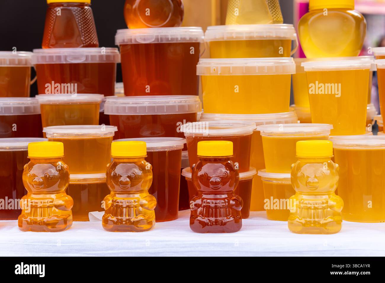 De nombreux pots au miel biologique frais sur le marché agricole. Miel coloré dans le pot sur le marché dans l'Altaï. Banque D'Images
