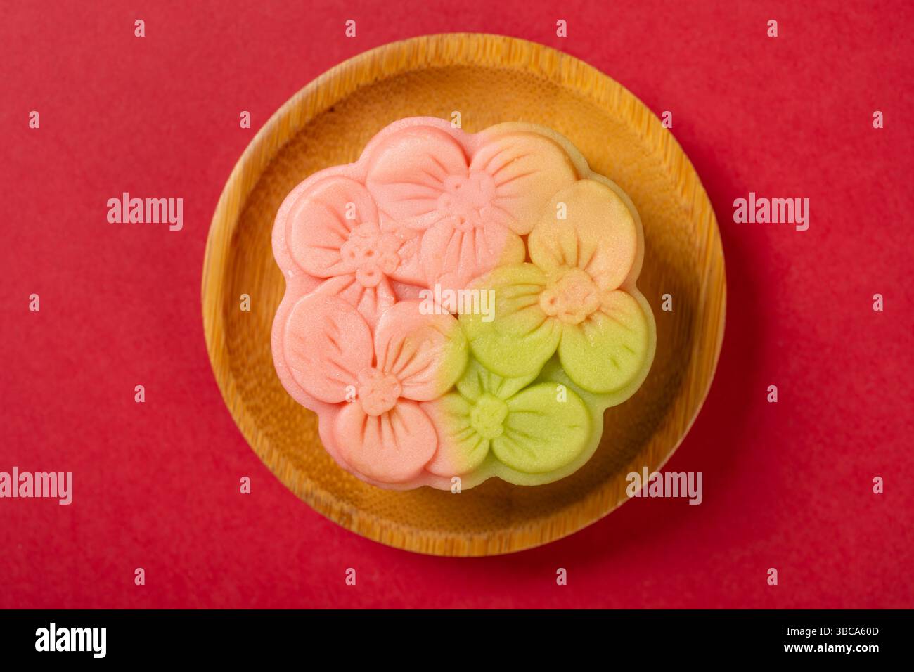 vue de dessus forme de fleur rose et vert mooncake sur rouge Banque D'Images