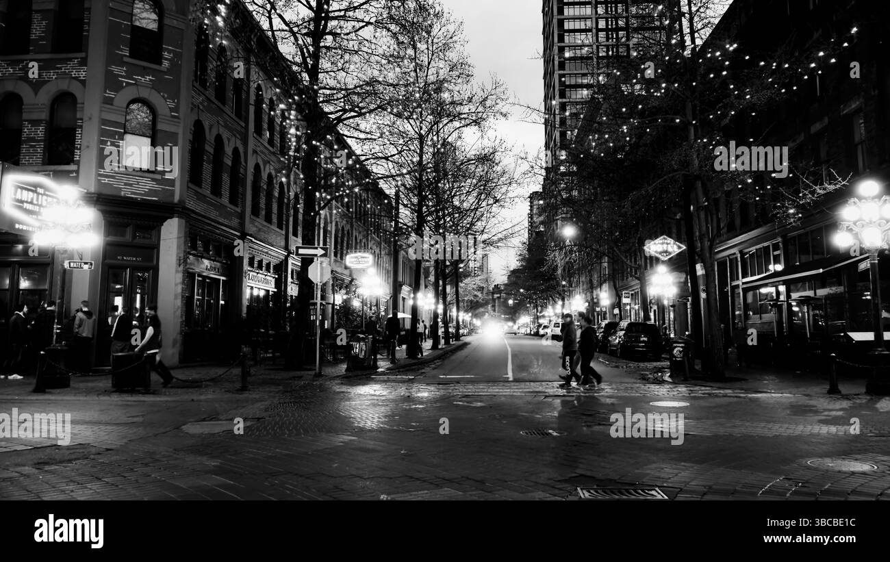 PRÉTEXTE piétons traversant la rue gastown au crépuscule à Vancouver, Canada, photographie en noir et blanc Banque D'Images