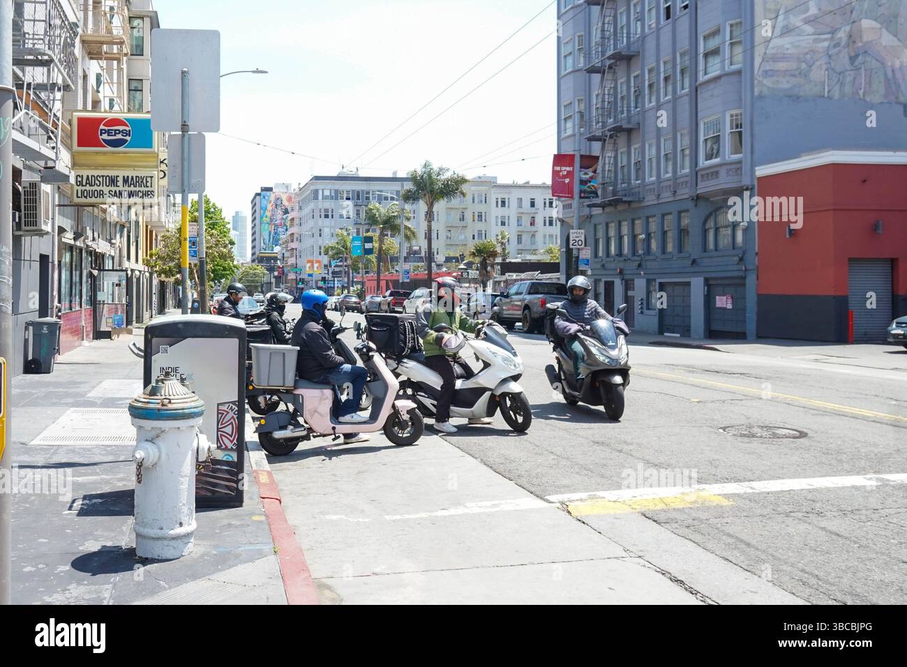 Un groupe de livreurs sur scooters se réunit et attend que la prochaine commande à emporter soit placée. Banque D'Images