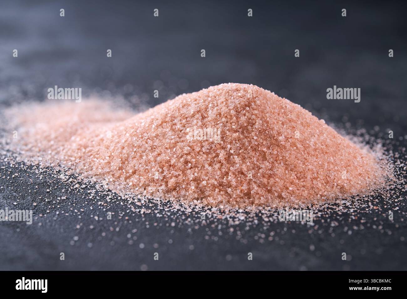 Tas de sel de l'himalaya sur une table noire, foyer sélectif. Cristaux de sel sur table. Banque D'Images