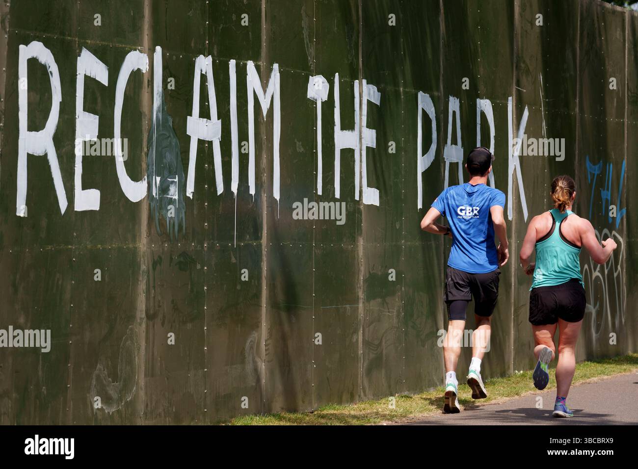Quelques jours avant le premier d'une série de festivals d'été, des graffitis et des messages de protestation ont été dessinés autour du grand mur périphérique de l'événement qui entoure une grande partie du Brockwell Park à Herne Hill, lambeth, le 19 mai 2025, dans le sud de Londres, en Angleterre. Les militants locaux affirment que le conseil municipal de Lambeth n’avait pas le bon permis de construire et que la semaine dernière, il a remporté une contestation devant la haute Cour pour l’utilisation d’un parc dans le sud de Londres pour des festivals de musique cet été. Le Conseil de Lambeth a permis au parc Brockwell, près de Herne Hill, d'accueillir une série d'événements tout au long de l'été, comme le Mighty Hoopla, wh Banque D'Images