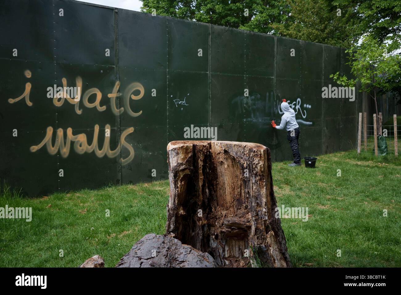 Quelques jours avant le premier d'une série de festivals d'été, a Cleaner tente d'enlever les graffitis et les messages de protestation qui ont été dessinés autour du grand mur d'enceinte de l'événement qui encercle une grande partie de Brockwell Park à Herne Hill, lambeth, le 19 mai 2025, dans le sud de Londres, en Angleterre. Les militants locaux affirment que le conseil municipal de Lambeth n’avait pas le bon permis de construire et que la semaine dernière, il a remporté une contestation devant la haute Cour pour l’utilisation d’un parc dans le sud de Londres pour des festivals de musique cet été. Lambeth Council a permis à Brockwell Park, près de Herne Hill, d'accueillir à nouveau une série d'événements tout au long de la s. Banque D'Images
