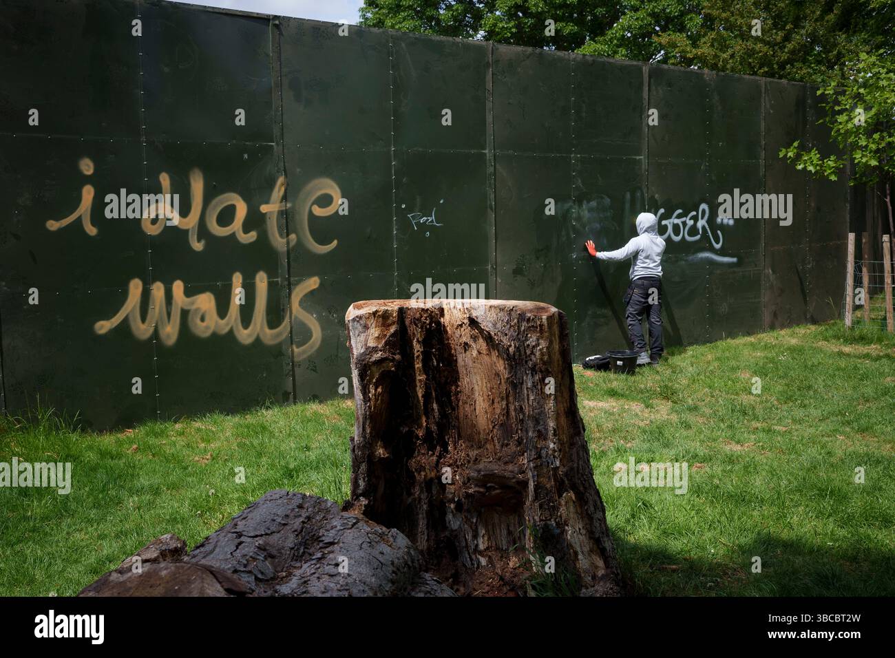 Quelques jours avant le premier d'une série de festivals d'été, a Cleaner tente d'enlever les graffitis et les messages de protestation qui ont été dessinés autour du grand mur d'enceinte de l'événement qui encercle une grande partie de Brockwell Park à Herne Hill, lambeth, le 19 mai 2025, dans le sud de Londres, en Angleterre. Les militants locaux affirment que le conseil municipal de Lambeth n’avait pas le bon permis de construire et que la semaine dernière, il a remporté une contestation devant la haute Cour pour l’utilisation d’un parc dans le sud de Londres pour des festivals de musique cet été. Lambeth Council a permis à Brockwell Park, près de Herne Hill, d'accueillir à nouveau une série d'événements tout au long de la s. Banque D'Images